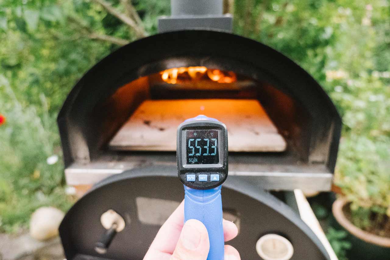 Bilde av IR termometer som tar temperatur i en pizzaovn vedfyrt viser 550c